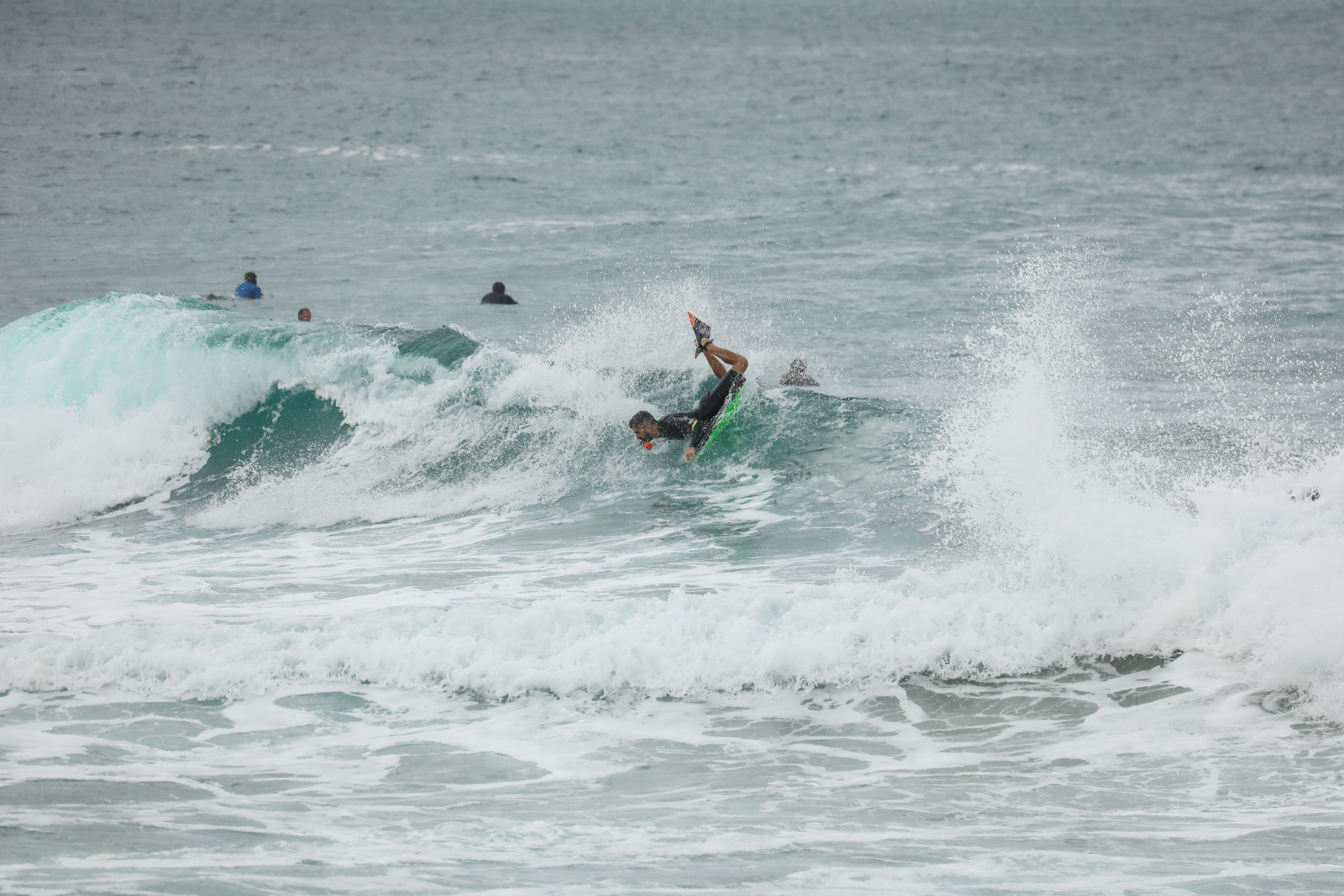 Bodyboarder performing a maneuver on a wave amid sea spray